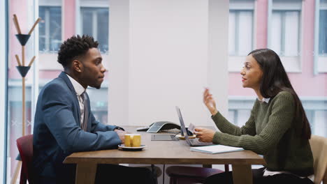 businesswoman interviewing male job candidate in meeting room