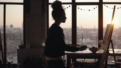 femaly artist working in a minimalistic loft styled art studio, finishing up her work, adding little detailes to the painting.