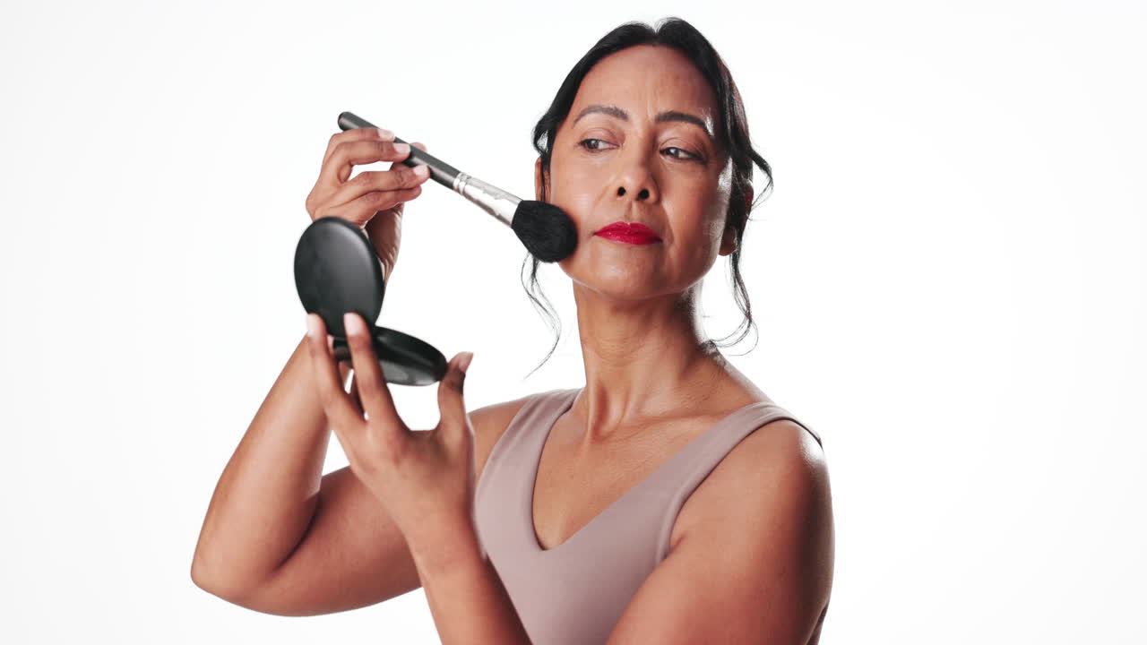 Donna matura che applica la cipria con un pennello da trucco.