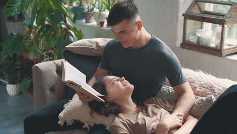 young man reads book to woman