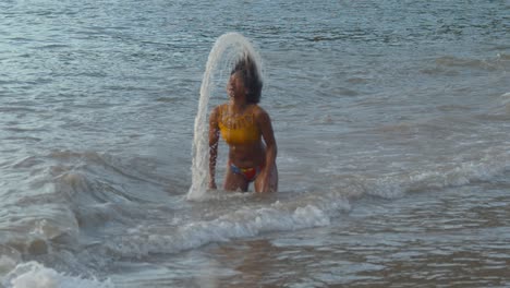 Cámara-Lenta-épica-De-Una-Niña-Saliendo-Del-Océano-Con-Su-Cabello-Creando-Un-Halo-Increíble-Con-El-Agua