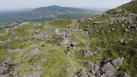 Drone-hovers-over-a-hiker-on-the-mountain's-hiking-trail-2