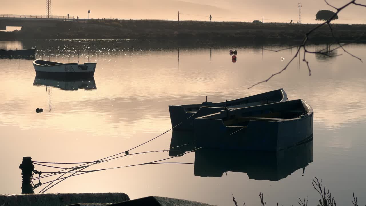 따뜻한 햇살 아래 해안선 근처에 묶여 있는 나무 보트 사진