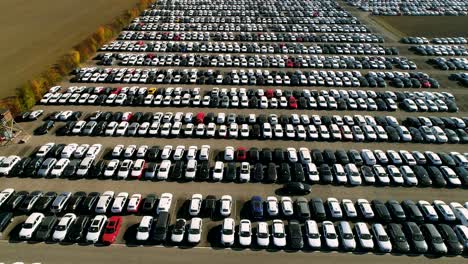 aerial footage of finished cars ready to be shipped on huge distribution center