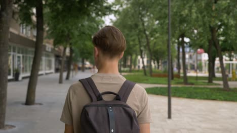 Slow-motion-POV-camera-shot-of-young-man-walking-home-from-university-with-backpack
