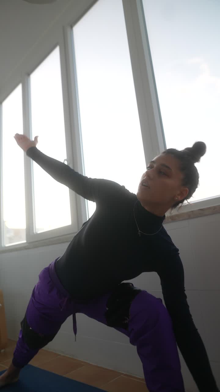 mujer practicando posturas de yoga en casa