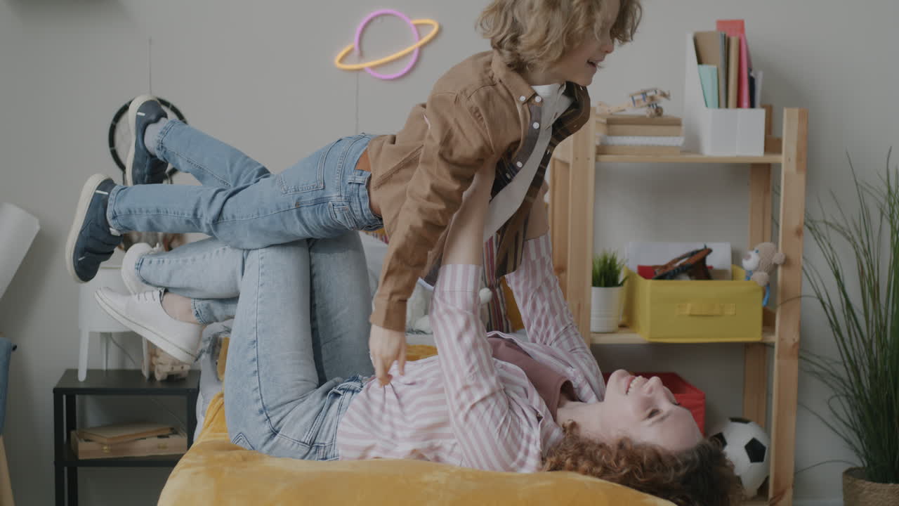Mother and son playing in a bedroom
