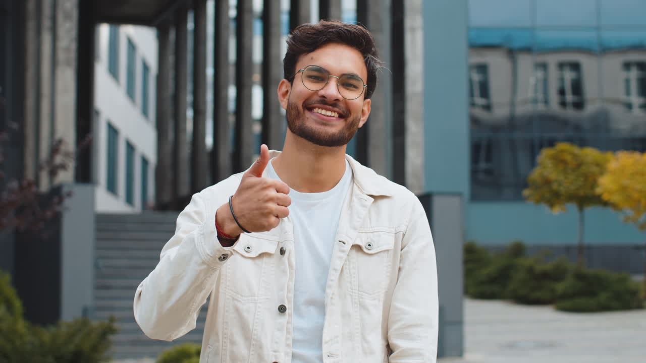 Happy indian man show thumbs up like sign positive something good positive feedback in city street