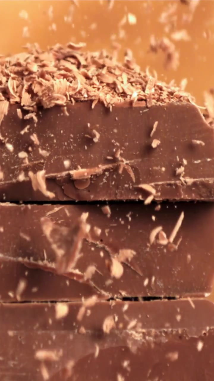 Slow Motion of Chocolate Shavings Falling on Stacked Chocolate Bars