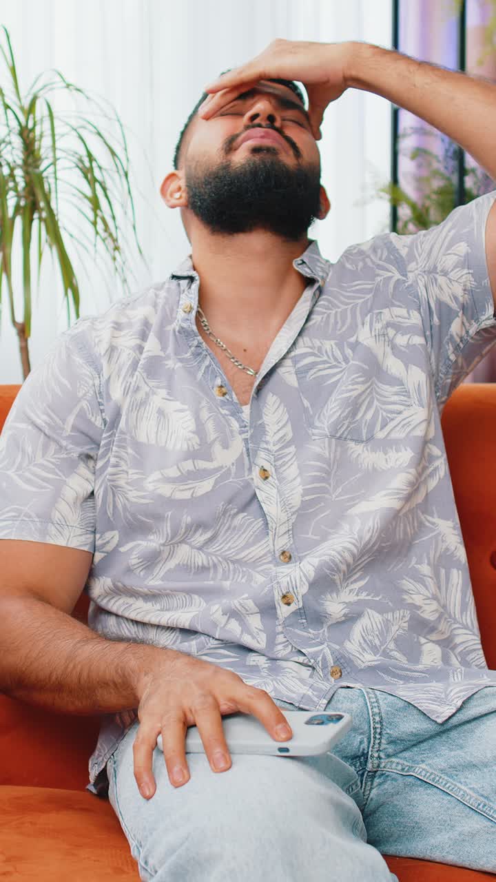 Sad indian man use smartphone surprised by bad news fortune loss fail lottery results deadline