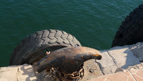 used car tire acting as a ship fender, absorbing impact during docking to protect the vessel's hull