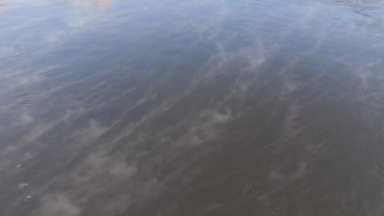 Detail shot of cold steam or sea smoke drifting over the dark, flowing waters of the Ottawa River in winter
