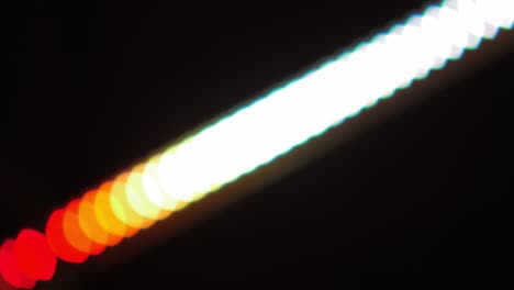 bokeh shot of defocused blurred christmas tree light that is blinking on black
