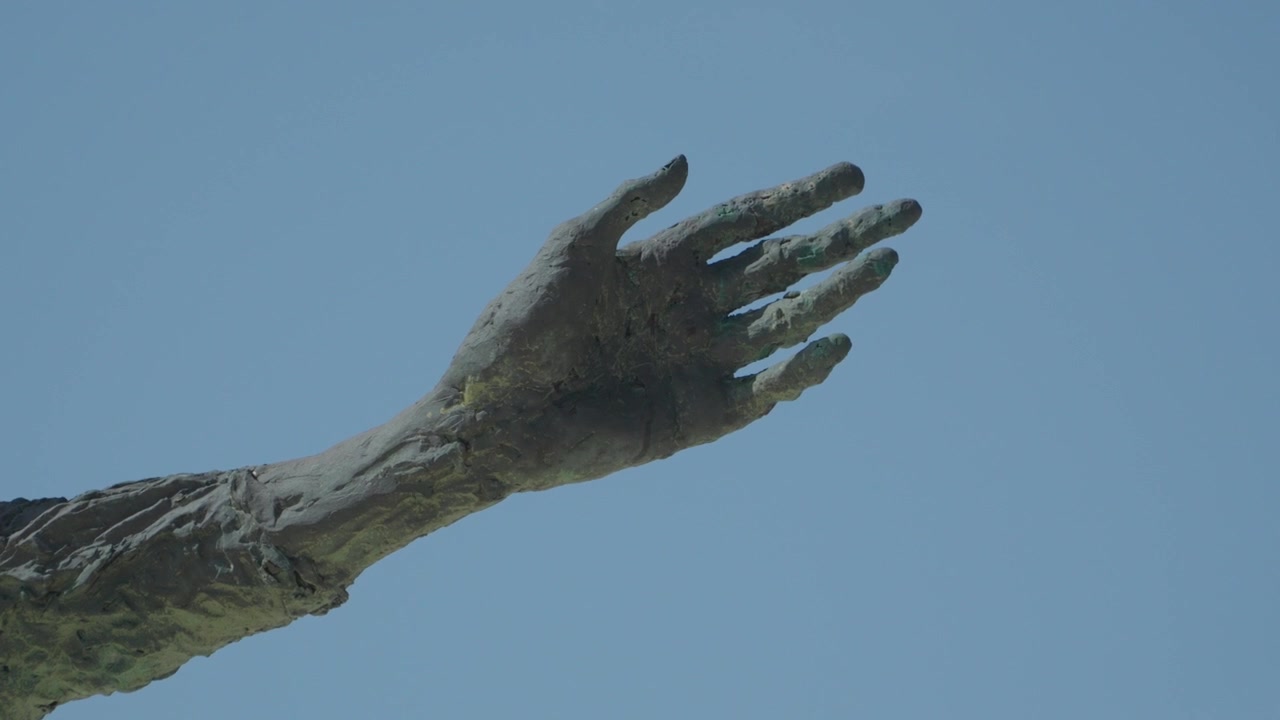 Primo piano del dettaglio della mano di bronzo sulla statua del Monumento alla Madre degli Immigrati a Gijón, Spagna.