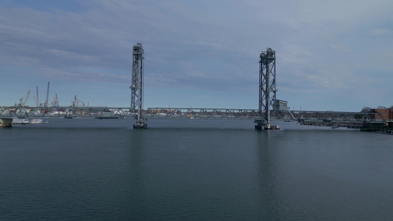 Approach dolly to New Hampshire Portsmouth Memorial bridge showcasing water reflections and harbor life
