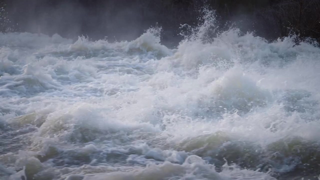 Turbulentes Wildwasser strömt im Frühling heftig durch die Sauble Falls auf der Bruce-Halbinsel. Dichter Schaum steigt zu einem schweren Nebel auf, während kalte Tropfen in die kühle Luft sprühen.