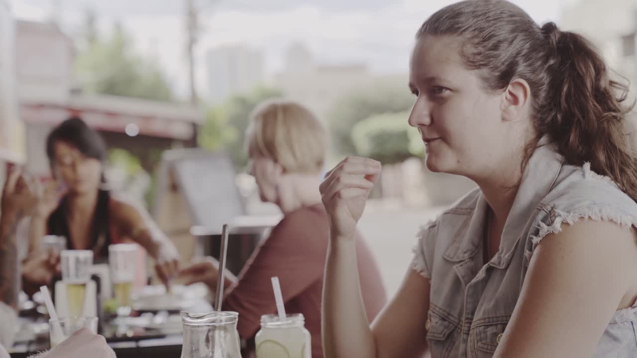Friends enjoying food and drinks at an outdoor restaurant