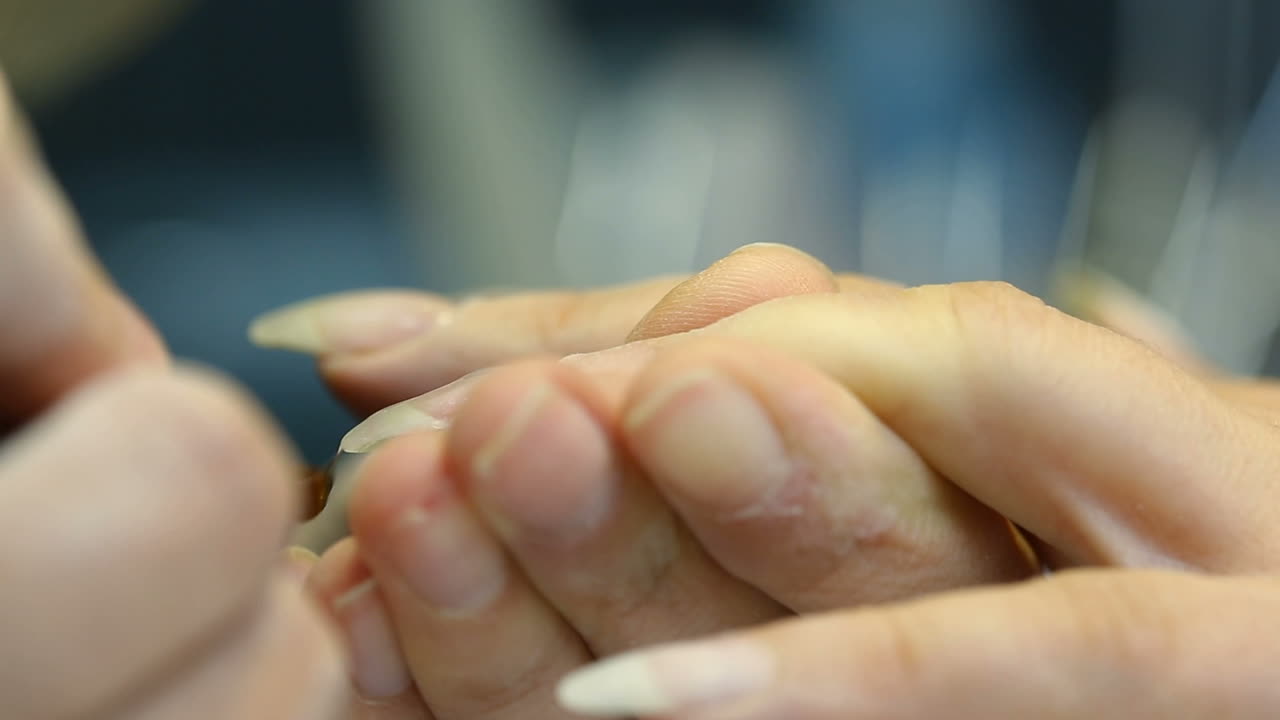Closeup shot of a woman in a nail salon receiving manicure by beautician