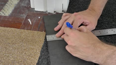 Using-metal-ruler-and-pen-to-measure-cut-in-points-in-carpet-trim