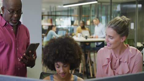 diverse male and female business colleagues talking and holding tablet