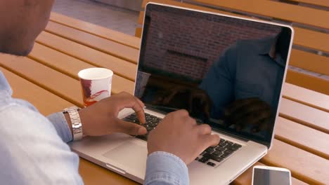 Over-shoulder-view-of-man-using-laptop