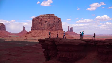 Touristen-Gehen-Auf-Einem-Felsvorsprung-Vor-Dem-Monument-Valley-1