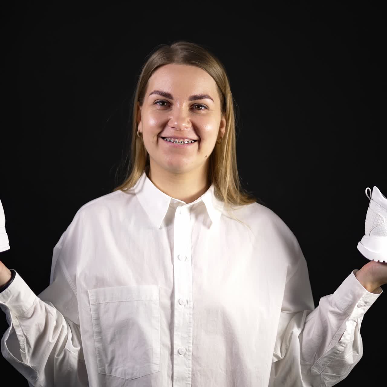 Portrait of woman with shoes in hands. Stylish shoes posing in studio. Elegance fashionable footwear posing