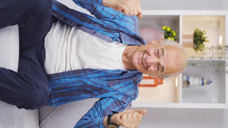 Vertical-video-of-The-old-man-looking-at-the-camera-applauds-and-congratulates-him.