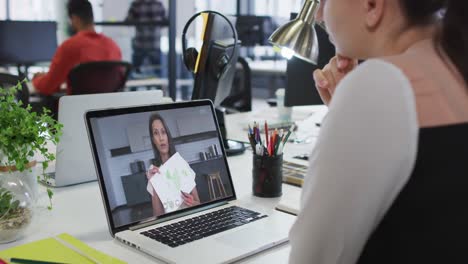 Caucasian-businesswoman-sitting-at-desk-using-laptop-having-video-call-with-female-colleague