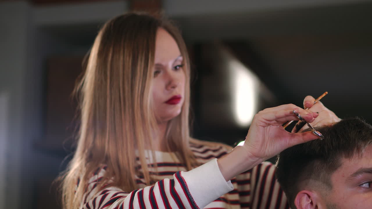 vista trasera de un cliente visitando a un peluquero y un peluquero en una barbería.