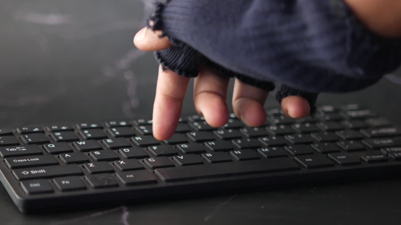 A hand typing on a keyboard