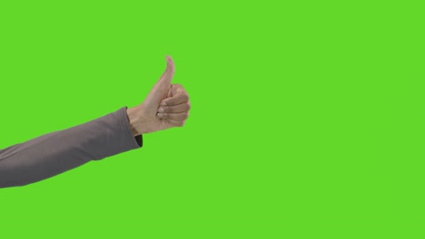 studio close up shot of woman giving thumbs up sign against green screen