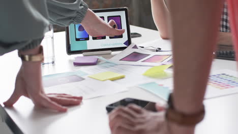 creative professionals in the business are examining color options on a computer screen, surrounded