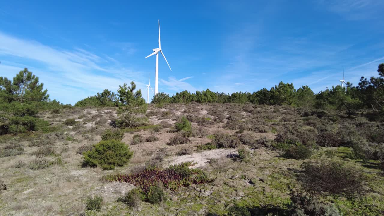 dos turbinas de viento girando rápidamente en un día soleado con cielos azules en portugal