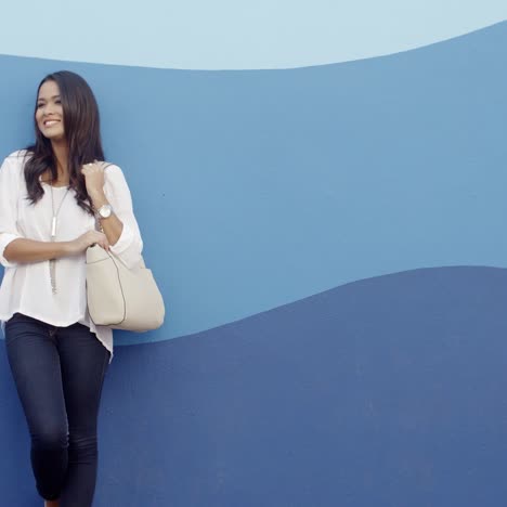 stylish cool girl against a blue wall