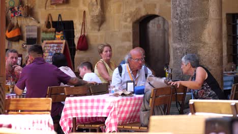 tourists seen dining outside in nicosia with child running past. slow motion