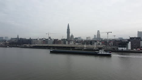 empty barge vessel passing by antwerp seaport at scheldt river,aerial