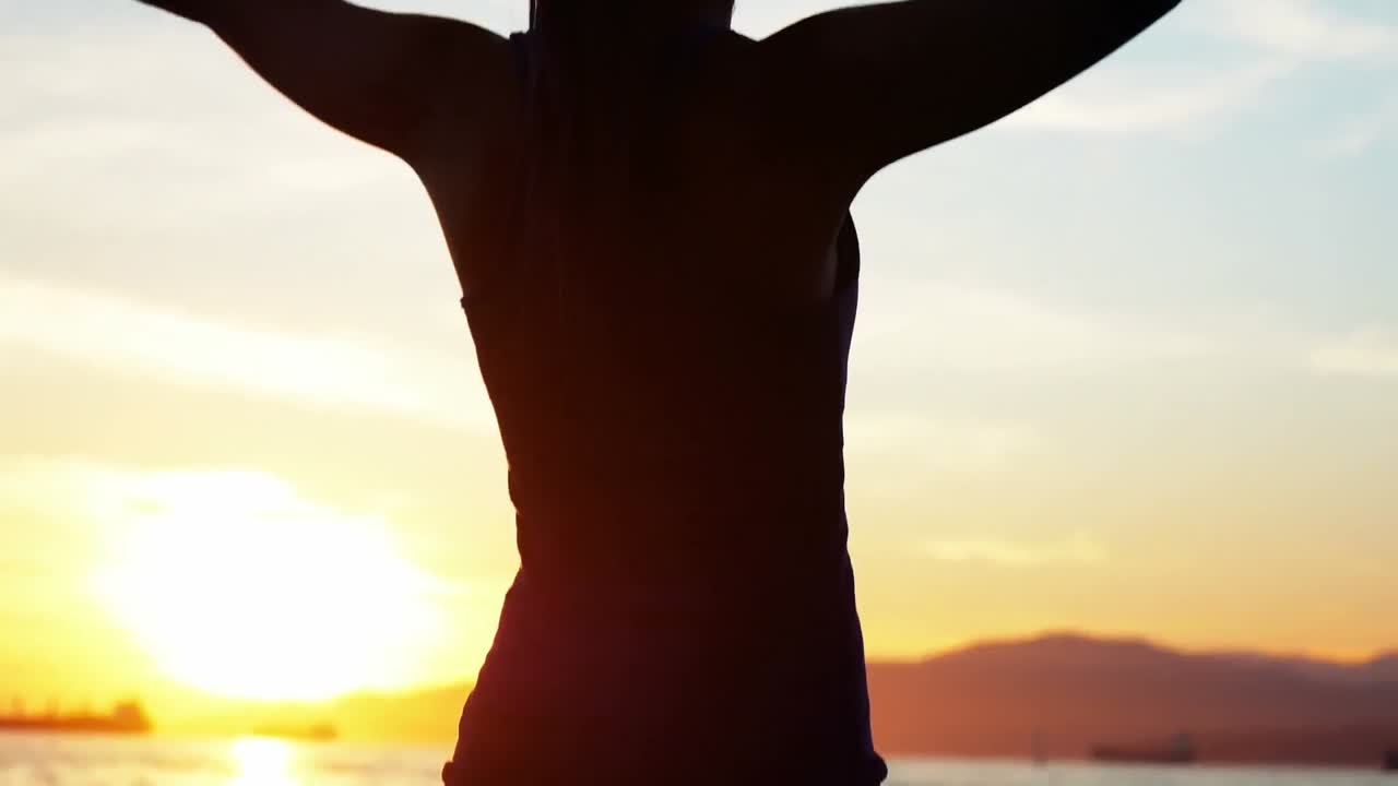 mujer realizando yoga en la playa
