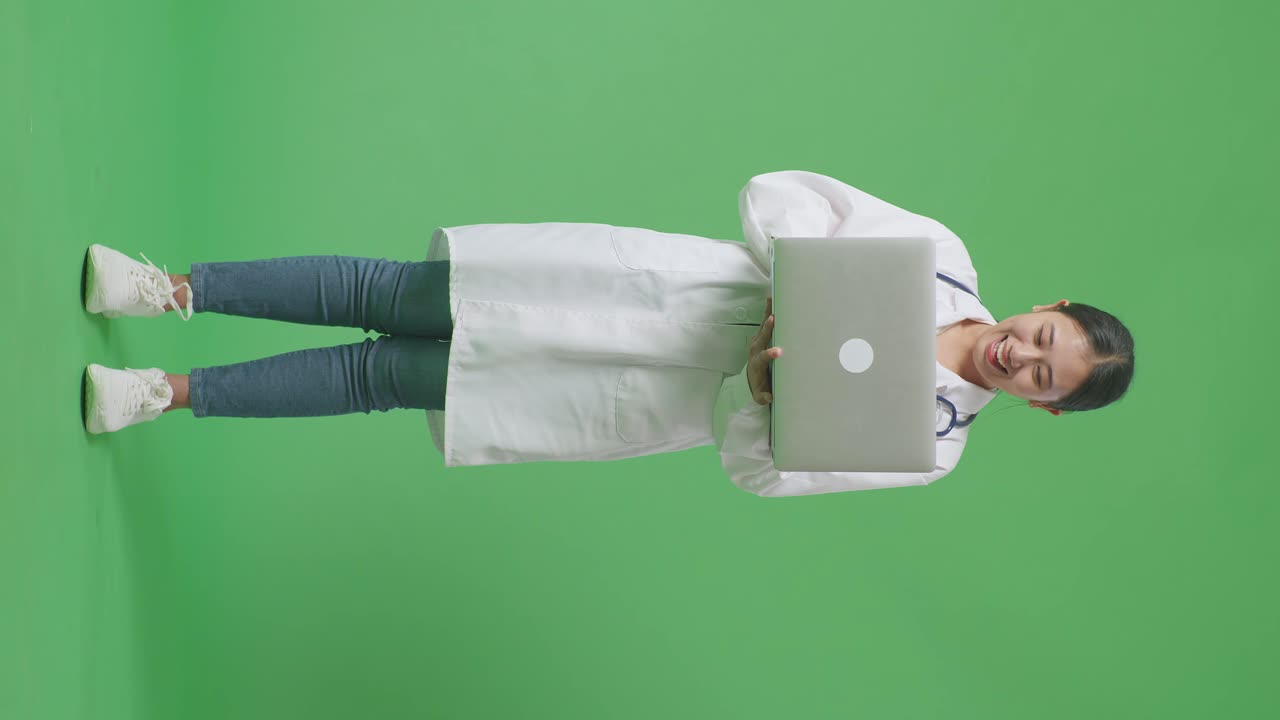 médico emocionado celebrando el éxito con la computadora portátil