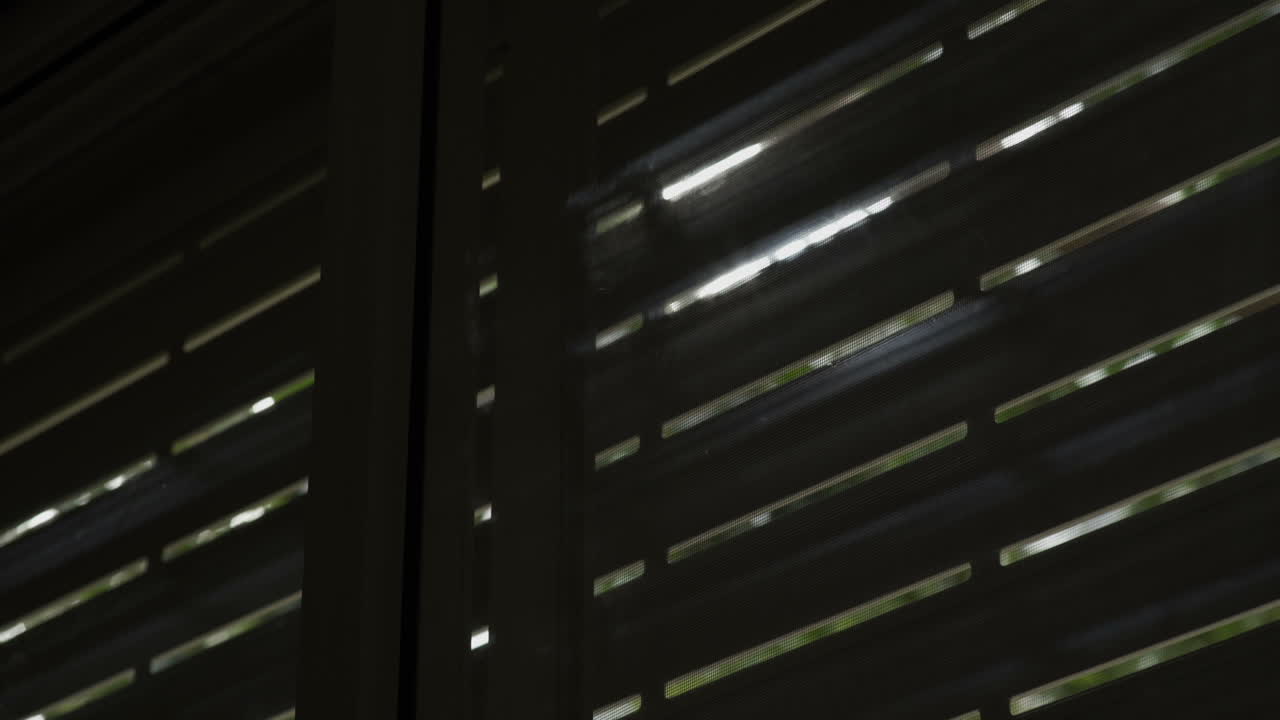 Sun shines through electric blinds going up until window is open completely