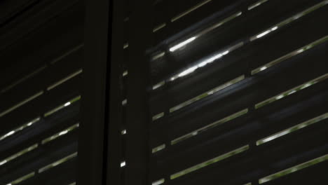 sun shines through electric blinds going up until window is open completely