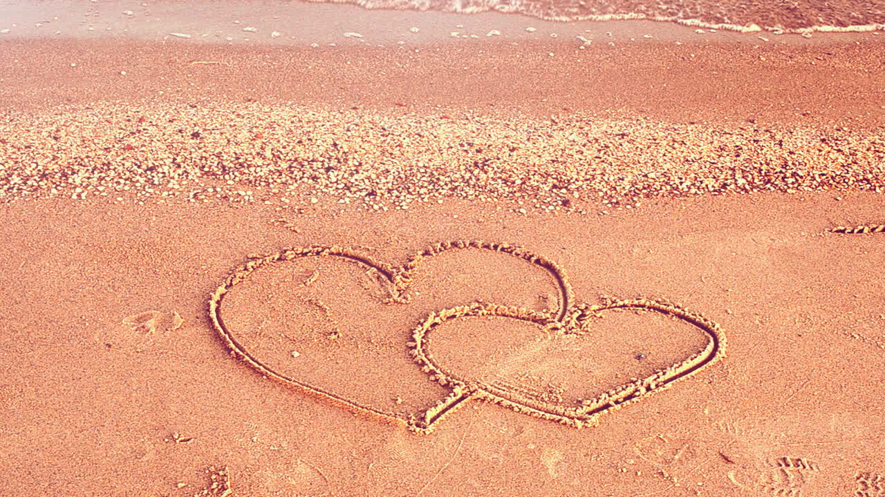 Two hearts on the beach. The loving hearts