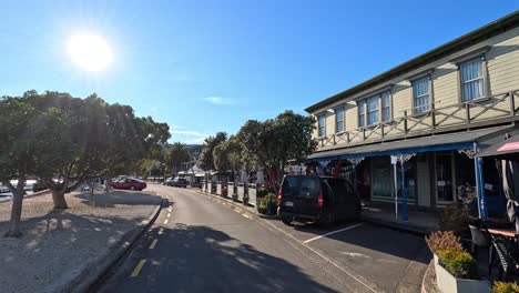 a serene walk along akaroa's waterfront, capturing vibrant street life and scenic views under bright sunlight