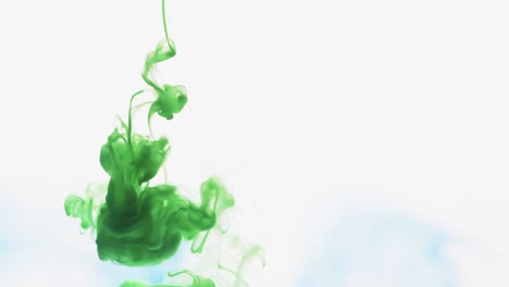 slow motion video of green watercolor ink mixing in water against grey background