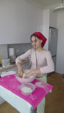 teenage girl baking bread in kitchen