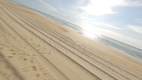 aerial fpv racing drone flying over sandy dunes and sea waters, landes department in france