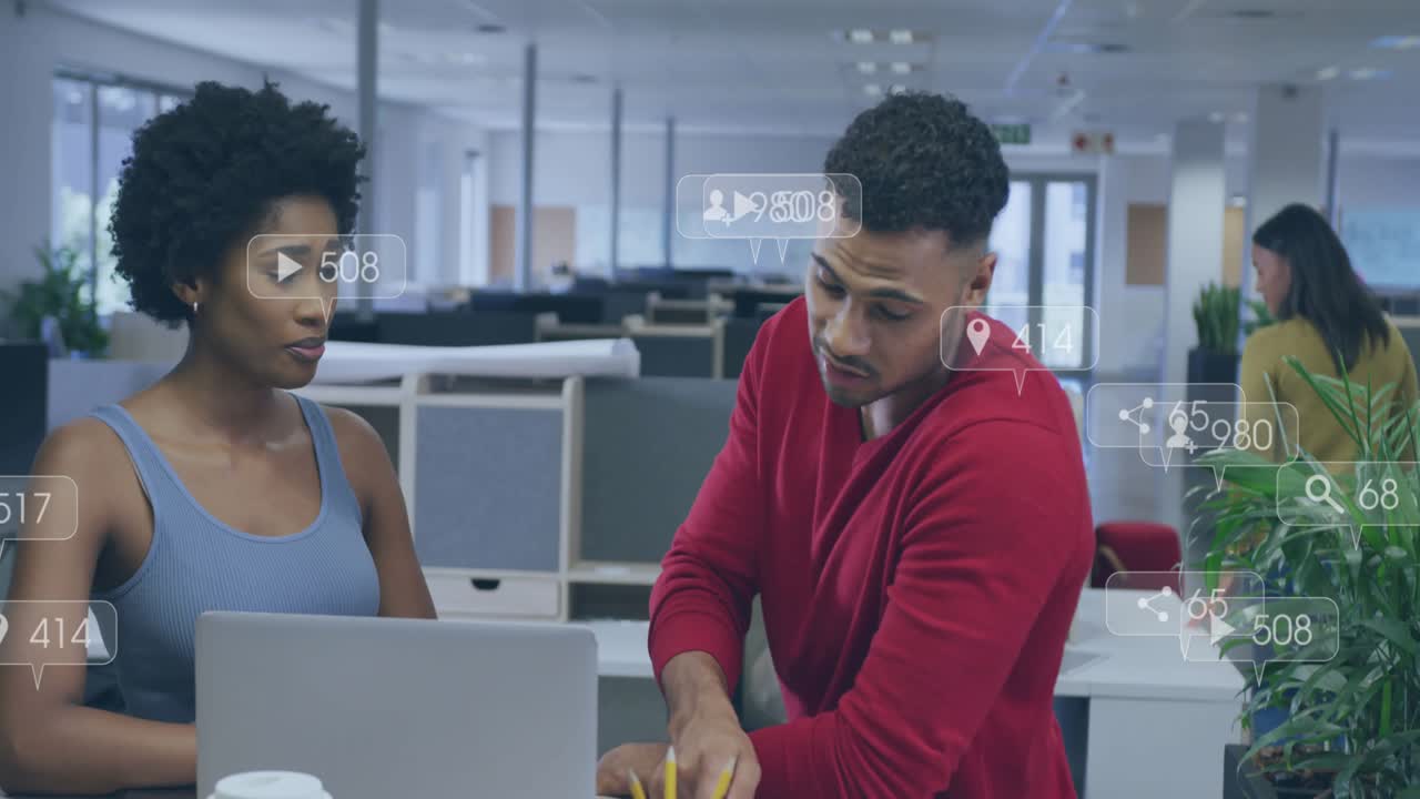 Woman speaking, gesturing at laptop while man pointing, reviewing marketing metrics overlaying desk