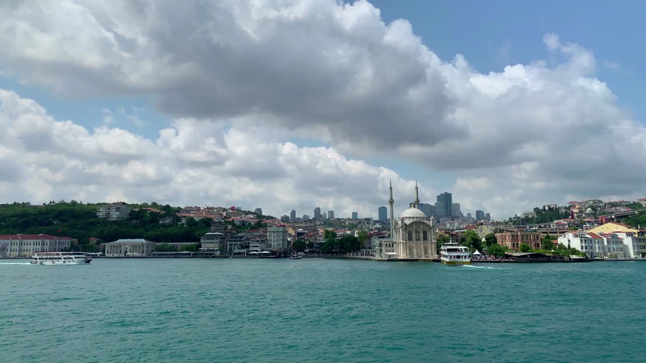 Footage of boats on Bosphorus, historical mosque called "Ortakoy" and cityscape of European side of Istanbul. It is a beautiful summer scene on cloudy summer day.