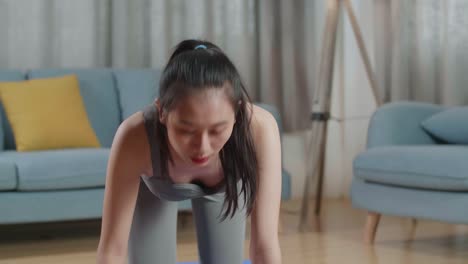 젊은 아시아 트레이너 스포츠 옷을 입은 여성이 집에서 운동을 가르치는 동안 균형 잡는 테이블 포즈에서 요가를 하고 이야기하고 있습니다.