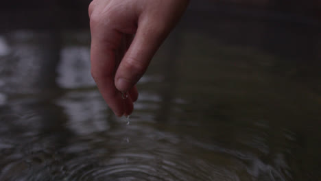 Weibliche-Hand-Taucht-Aus-Wasser-Auf-Und-Bildet-Tröpfchen-In-Zeitlupe